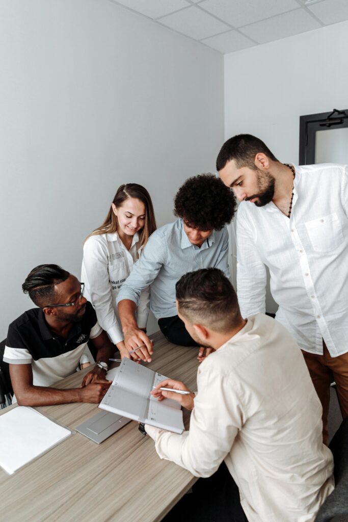 Business team working together around a table, discussing ideas and strategies indoors.